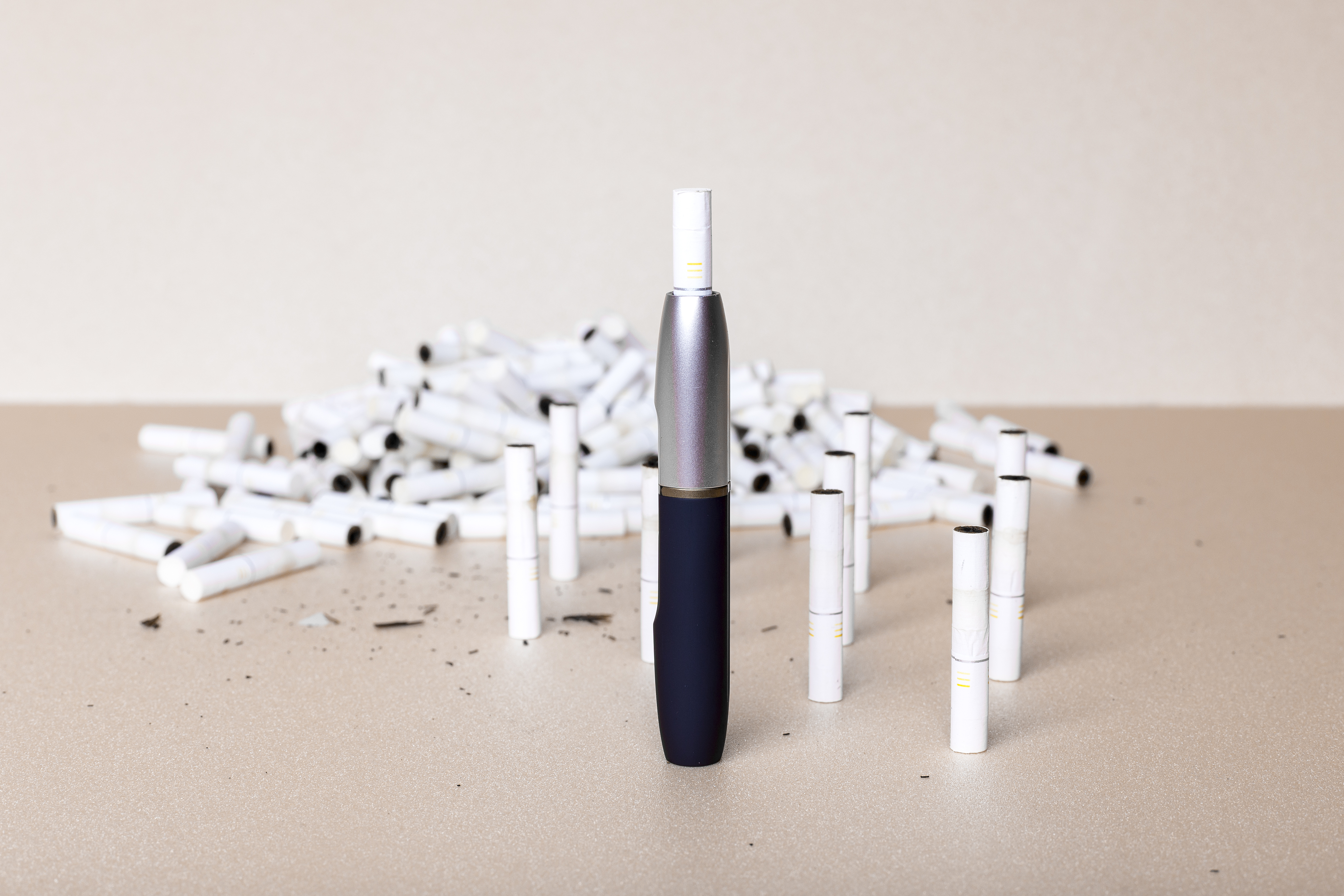iQOS heated tobacco product in the foreground with heat sticks littering the background